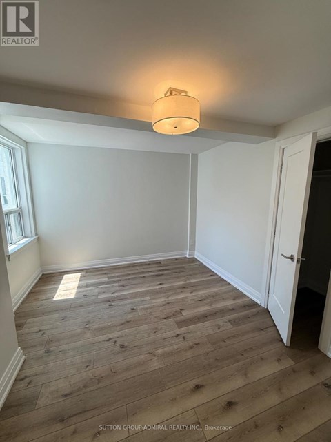 A room with wooden flooring and a light on the ceiling.