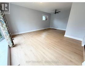 A room with wooden flooring and a ceiling fan.