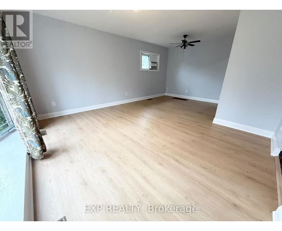 A room with wooden flooring and a ceiling fan.