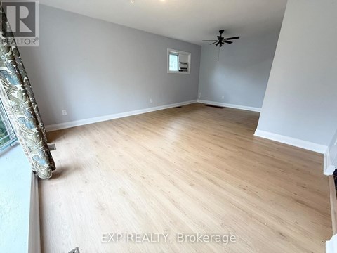 A room with wooden flooring and a ceiling fan.