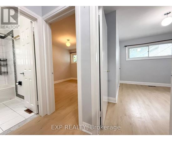 A bathroom with a walk-in shower and a wooden floor.