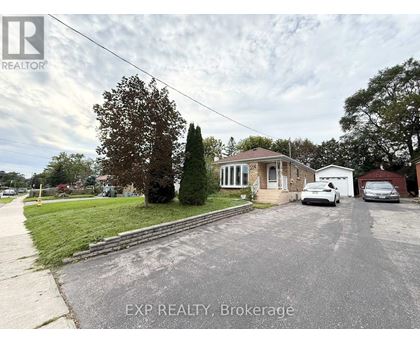 A house with a car parked in front and a tree to the left.