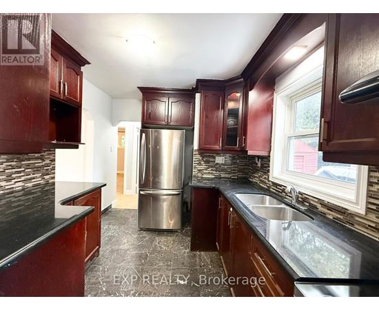 A kitchen with dark wood cabinets and a stainless steel refrigerator.
