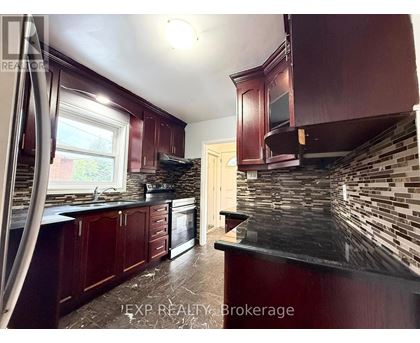 A kitchen with dark wood cabinets and a black countertop.
