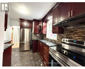 A kitchen with dark wood cabinets and stainless steel appliances.