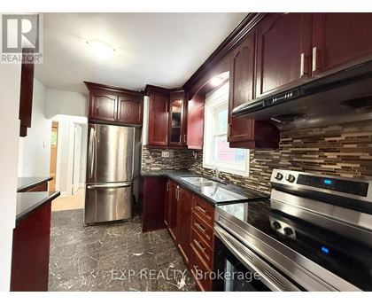 A kitchen with dark wood cabinets and stainless steel appliances.