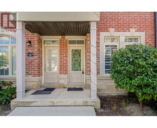 A red brick house with a white door and a sign that says "HOMELIFE LANDMARK REALTY INC."