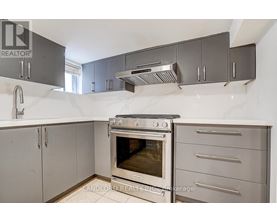 A kitchen with a stainless steel oven and cabinets.