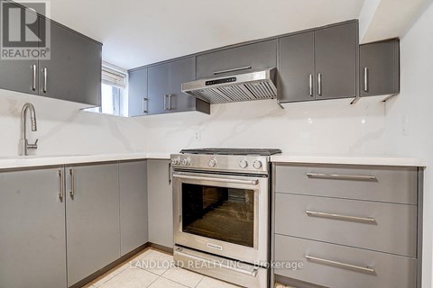 A kitchen with a stainless steel oven and cabinets.