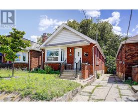 A small red brick house with a white door and a small porch.