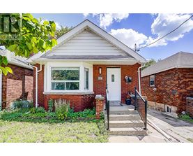 A small red brick house with a white door and a small front porch.