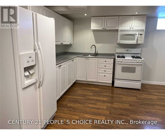 A kitchen with white appliances and cabinets.