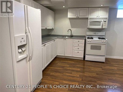 A kitchen with white appliances and cabinets.