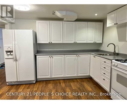 A kitchen with white cabinets and a white refrigerator.