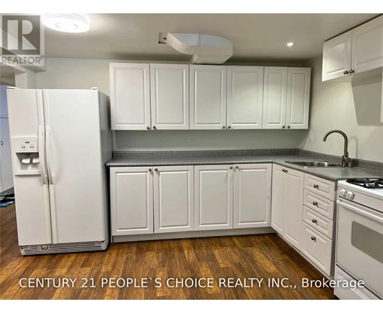 A kitchen with white cabinets and a white refrigerator.