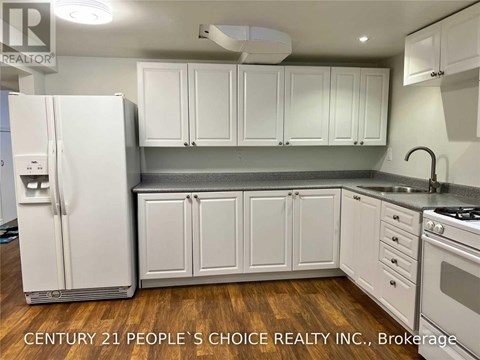 A kitchen with white cabinets and a white refrigerator.