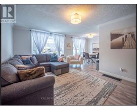A living room with a couch, chairs, and a rug.