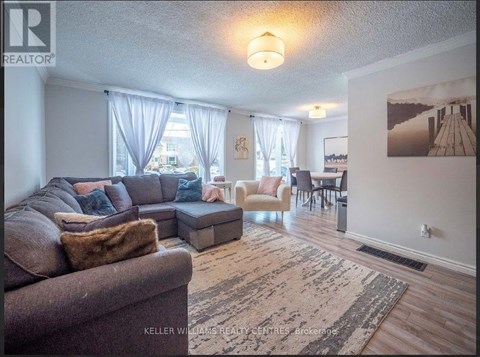 A living room with a couch, chairs, and a rug.