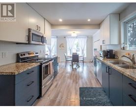 A kitchen with a granite countertop and stainless steel appliances.