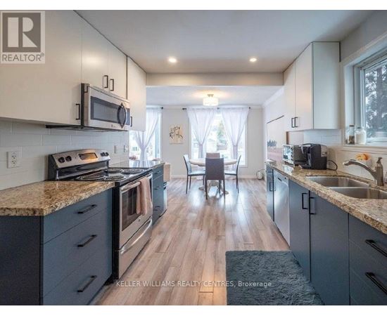 A kitchen with a granite countertop and stainless steel appliances.