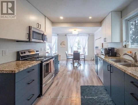 A kitchen with a granite countertop and stainless steel appliances.