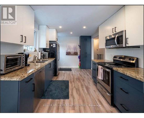 A modern kitchen with dark blue cabinets and stainless steel appliances.