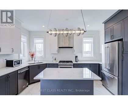A modern kitchen with a marble island and stainless steel appliances.