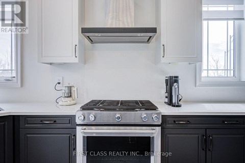A modern kitchen with a stove top oven and a coffee maker.