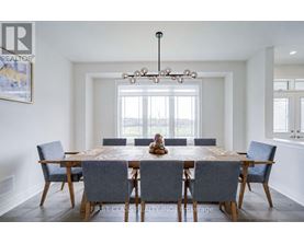 A dining room with a large table and chairs.