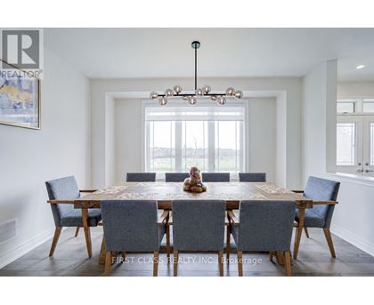 A dining room with a large table and chairs.