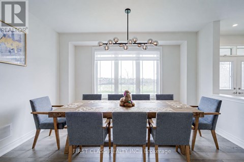 A dining room with a large table and chairs.