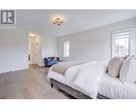 A bedroom with a large bed and a blue couch in the background.