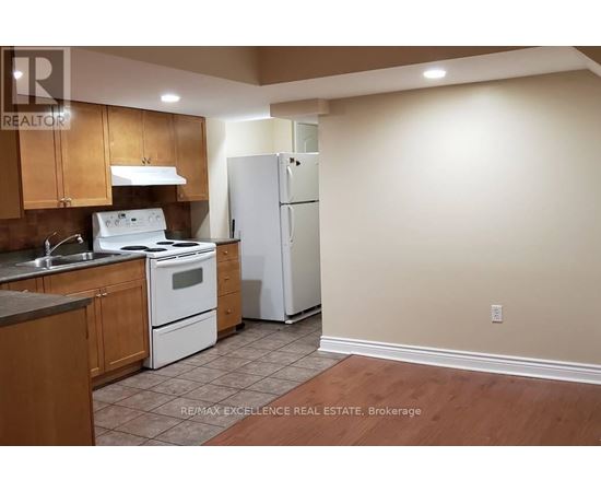 A kitchen with a white stove top oven and a white refrigerator.