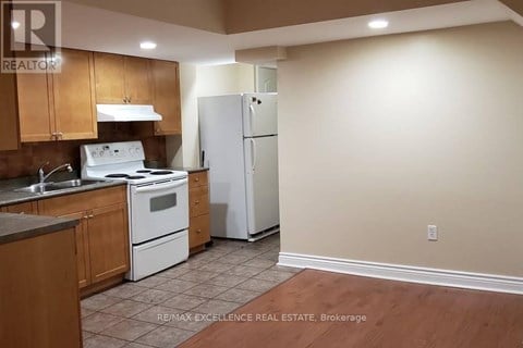 A kitchen with a white stove top oven and a white refrigerator.