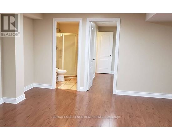 A room with a toilet and a doorway leading to another room.