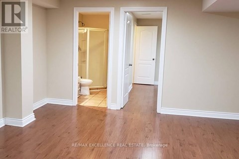 A room with a toilet and a doorway leading to another room.