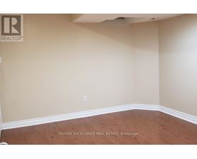 A room with a wooden floor and beige walls.