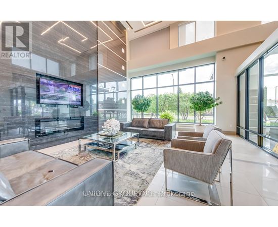 A modern living room with a large television and comfortable seating.