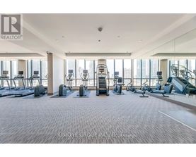 A spacious gym with a variety of equipment including treadmills, elliptical machines, and weight machines.