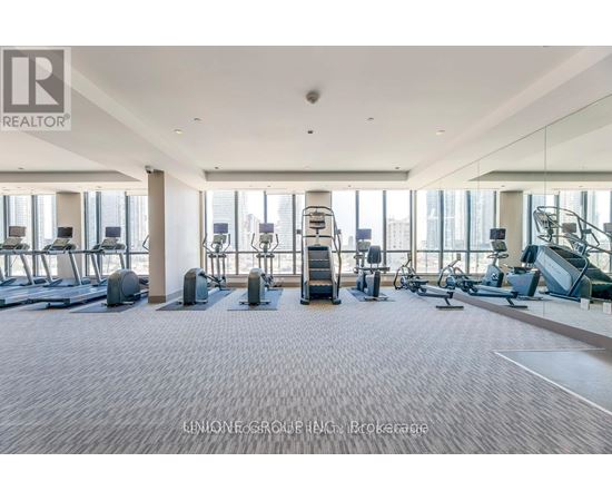 A spacious gym with a variety of equipment including treadmills, elliptical machines, and weight machines.