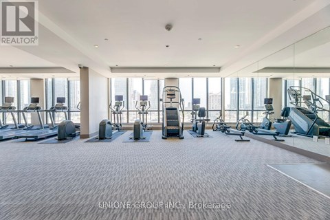 A spacious gym with a variety of equipment including treadmills, elliptical machines, and weight machines.