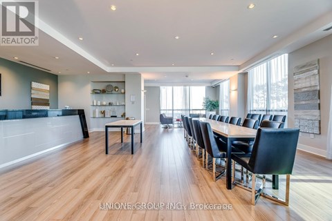 A modern dining room with a long table and chairs.