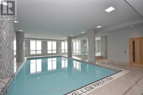 A large indoor swimming pool with a sign that says "RE/MAX CROSSROADS REAL ESTATE".