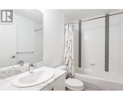A white bathroom with a marble sink and a toilet.