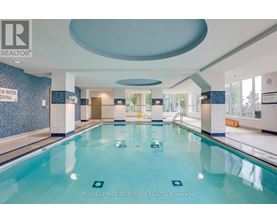 A large indoor swimming pool with a sign that says "ROYAL LEPAGE SIGNATURE REALTY, Brokerage".