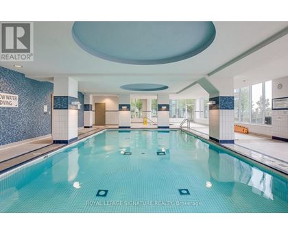 A large indoor swimming pool with a sign that says "ROYAL LEPAGE SIGNATURE REALTY, Brokerage".