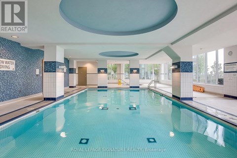 A large indoor swimming pool with a sign that says "ROYAL LEPAGE SIGNATURE REALTY, Brokerage".