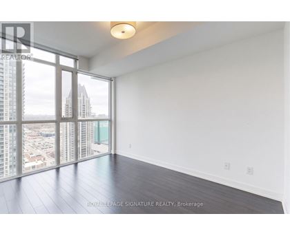 A large, empty room with a view of the cityscape outside the window.