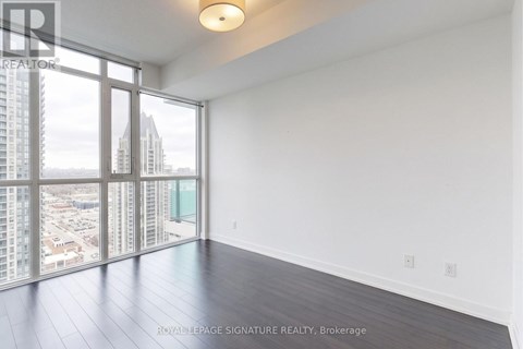 A large, empty room with a view of the cityscape outside the window.