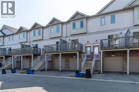 A row of townhouses with garages in front.